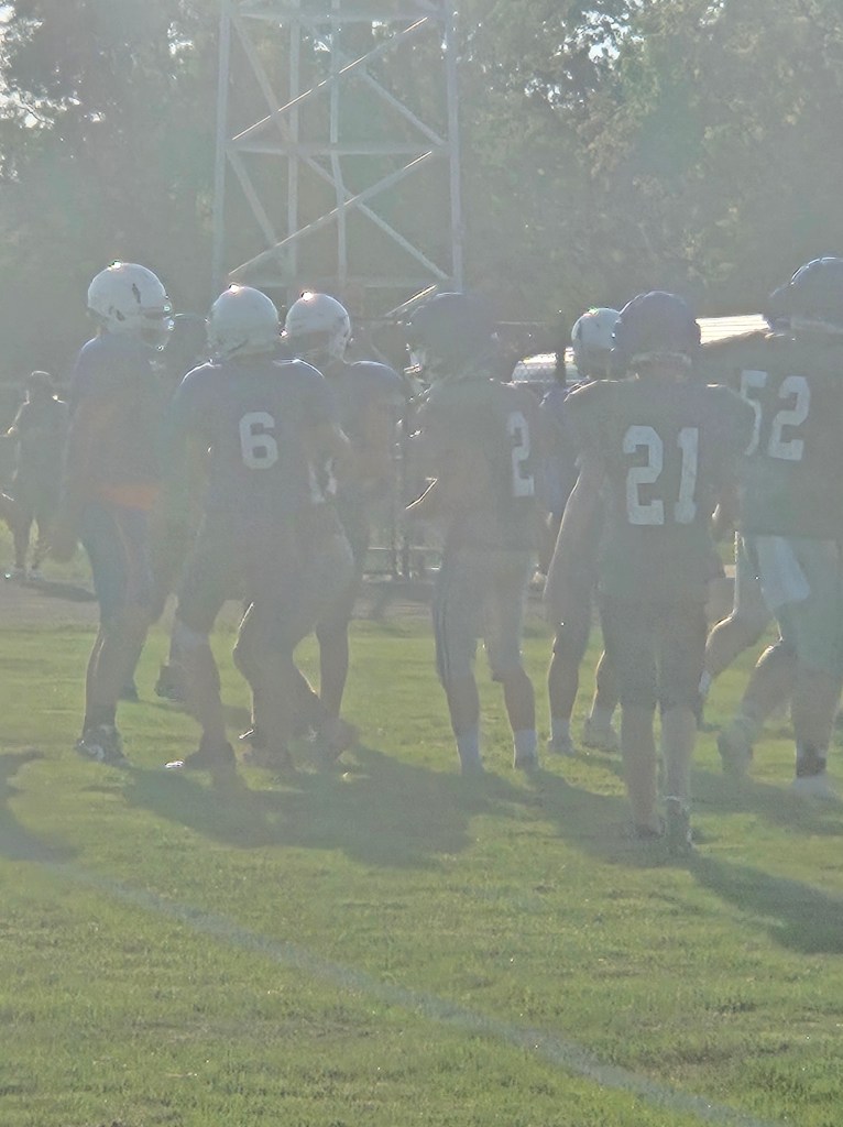 Football players from the Crestview Knights team gathered on the field during a scrimmage practice, with a focus on teamwork and strategy.
