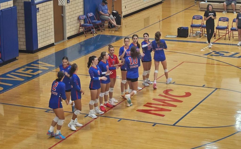 Crestview Lady Knights volleyball team in a huddle on the court, preparing for the game.