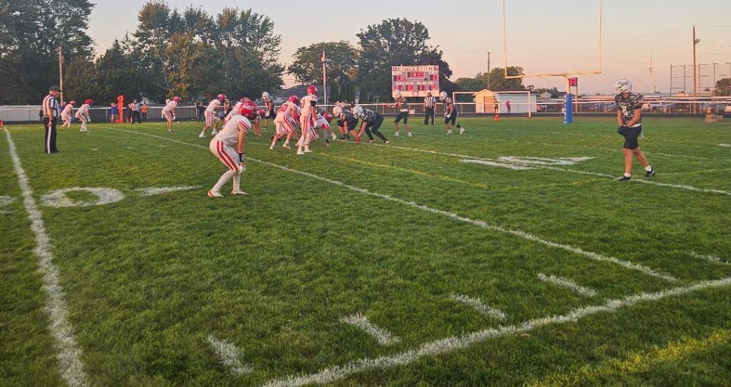 High school football game in Convoy, Ohio, featuring Crestview Knights in special uniforms and Delphos Jefferson Wildcats on the field with a scoreboard in the background.