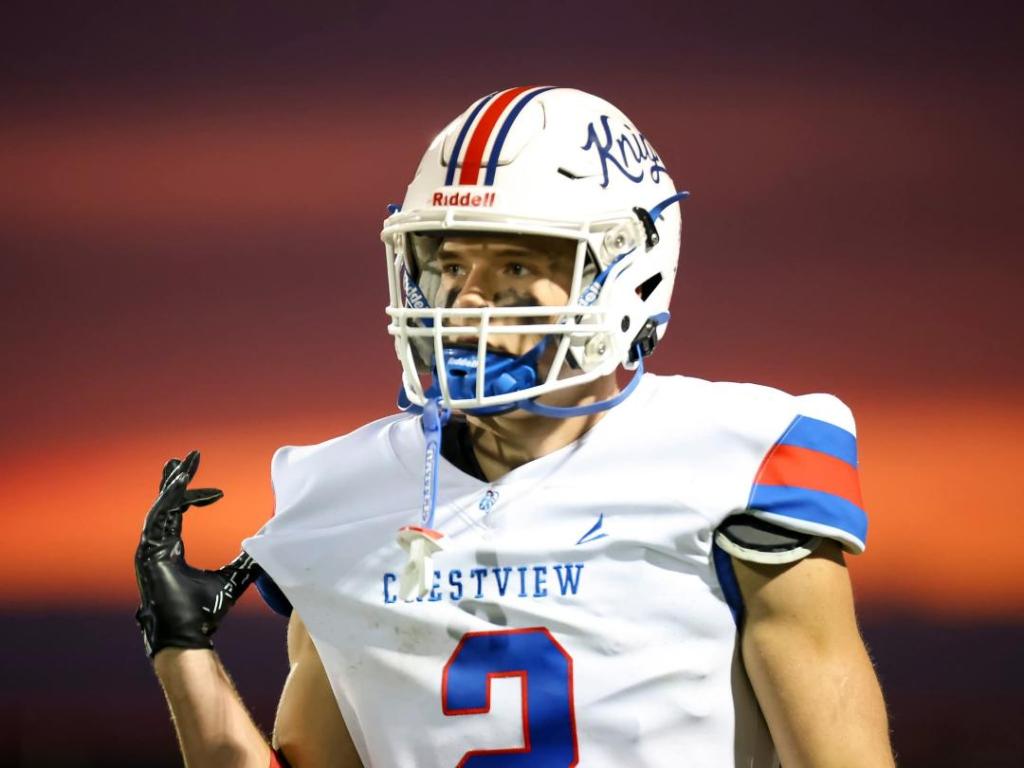Crestview Knights football player celebrating on the field during a game at sunset.
