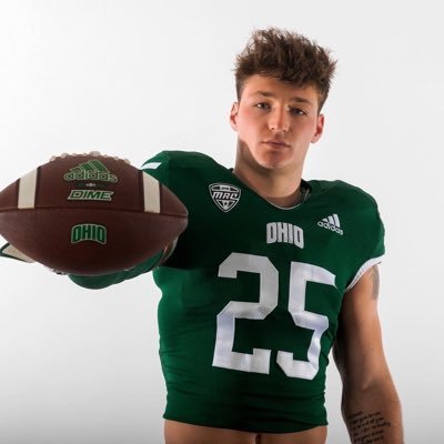 Football player wearing a green Ohio jersey with the number 25, holding a football in front of him against a white background.